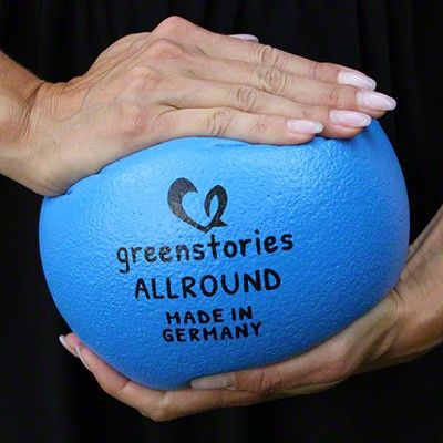 greenstories Softball in blau wird zwischen zwei Händen zusammengedrückt