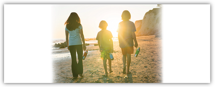 Familie am Strand mit Pura Kiki Flaschen