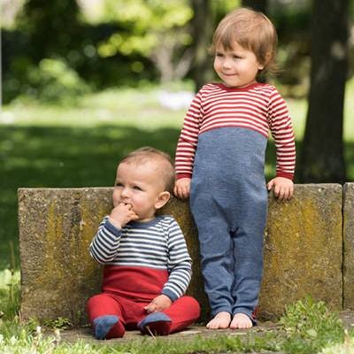 Zwei Geschwister draußen im Garten: Das Baby sitzt mit dem Rücken an eine kleine Mauer gelehnt. Seine große Schwester steht daneben und stützt sich auf der Mauer ab. Zwei Geschwister draußen im Garten: Das Baby sitzt mit dem Rücken an eine kleine Mauer gelehnt. Seine große Schwester steht daneben und stützt sich auf der Mauer ab.