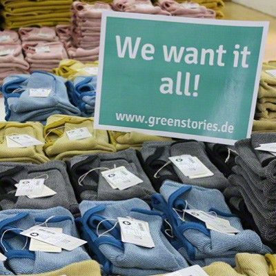 Viele bunte Baby-Pullover von disana und ein Schild, auf dem steht "We want it all!"