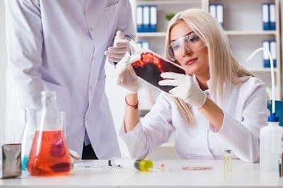 Forscherin untersucht in einem Labor Blut.