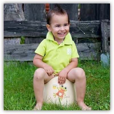 Kind sitzt glücklich im Garten auf dem Rotho-Töpfchen der Bio-Linie