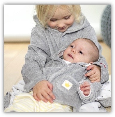 Kindermode People wear organic Ein Kleinkind mit einem Baby auf dem Schoß. Beide haben graue Pullover an, die gleich aussehen.