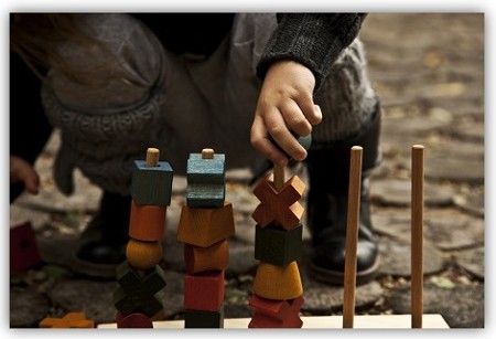 Ein Kind mit einem Steckspiel draußen.