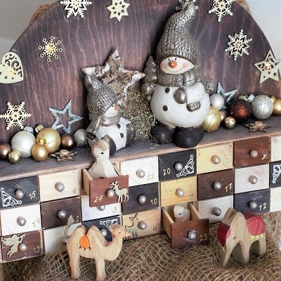 Holzadventskalender sind besonders nachhaltig und robust Ein Adventskalender aus Holz mit 24 Schubladen und weihnachtlicher Deko