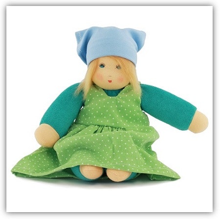 Nanchen Stoffpuppe Eine Stoffpuppe mit dezenten, aufgemalten Gesicht. Sie hat Haare aus Wolle, ein Kopftuch, und ein grünes Kleid an.