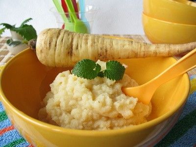 Eine Schüssel mit Pastinaken-Brei. Auf dem Schüsselrand balanciert eine Pastinake