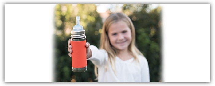 Mädchen hält eine Pura Kiki Flasche hoch