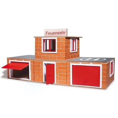 Ein 2-stöckiges Haus mit Garagen, Tür und Fenstern aus kleinen Steinen gebaut. Obendrauf ein Schild mit "Feuerwehr"