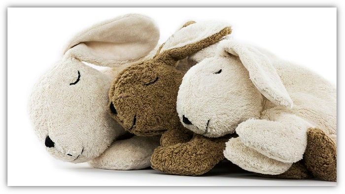 Drei Kuscheltierhasen vor weißem Hintergrund. Zwei in weiß und einer in braun.