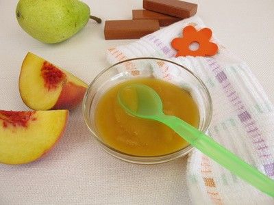 Selbstgemachter Obst-Brei in einer Schale, daneben liegen Pfirsich-Stücke uns eine Birne