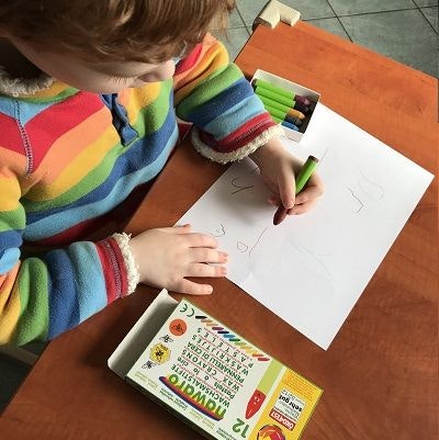 Schon beim Malen können Kindern im Kindergarten erste Schwungübungen machen Kind, das malt und dabei automatisch Schwungübungen macht