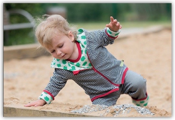 Kind beim Spielen im Sandkasten in loud and proud Kleidung Kind beim Spielen im Sandkasten in loud and proud Kleidung