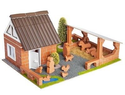 Ein aus kleinen Steinen zusammengebauter Bauernhof, mit Spielfiguren