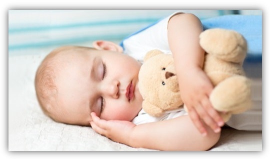 Baby mit Kuscheltier Ein schlafendes baby mit einem Teddybären im Arm