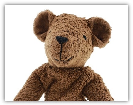 Bio-Teddybär mit aufgenähtem Gesicht Man sieht den Kopf und den Oberkörper eines dunkelbraunen Teddybäres. Augen und Nase, Mund sind aufgenäht.