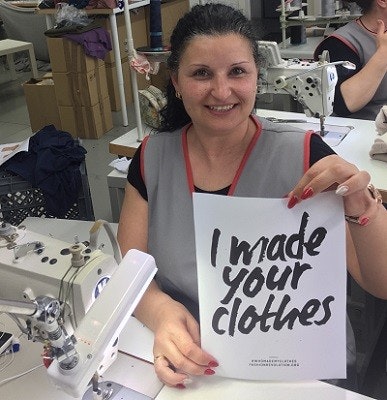 Arbeiterin bei Loud and Proud hält Schild hoch mit der Aufschrift "I made your clothes" Arbeiterin bei Loud and Proud hält Schild hoch mit der Aufschrift "I made your clothes"