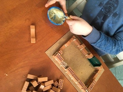 teifoc Pferdestall Ein Kind beim Mauern mit dem teifoc Bauset