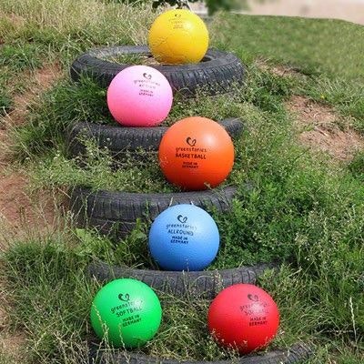 greenstories Softball Softbälle draußen aufgereiht in vielen verschiedenen Farben