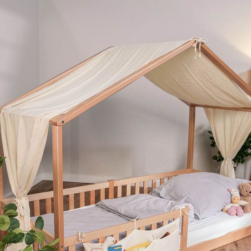 Ein Bodenbett mit Dach und beigem Baldachin