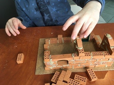 teifoc Steinbaukasten Ein Kind beim Mauern mit dem teifoc Bauset.