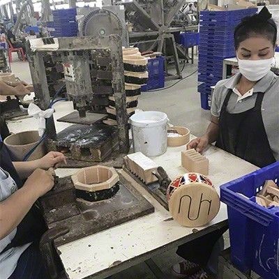 Die Fertigung einer Kinder-Holztrommel bei PlanToys PlanToys-Mitarbeitende bei der Fertigung der Holztrommel für Kinder