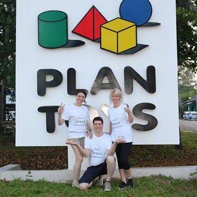 Inna und Denver Mielke mit einer Mitarbeiterin vor dem großen PlanToys-Schild