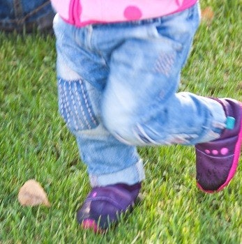 Lieblinge Krabbelschuhe für draußen Kinderfüße, die Leder-Krabbelschuhe anhaben, auf Rasen