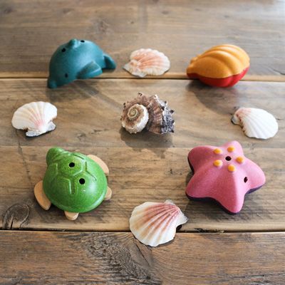 Die 4 Spielzeuge liegen mit Muscheln in einem Kreis auf einem Tisch