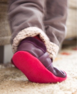 Lieblinge Krabbelschuhe Kinderfüße, die Leder-Krabbelschuhe anhaben, auf Teppichboden