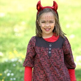 Einfaches Teufelkostüm für Kinder aus rot-schwarz gemusterten T_Shirt, Jeans, Teufelshörner auf dem Kopf und ein Dreizack ins Gesicht gemalt