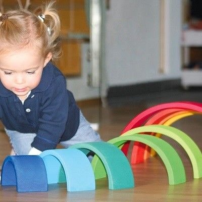Kleines Mädchen spielt mit dem Regenbogen von Grimms